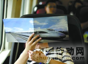 運(yùn)行的高鐵列車上，一名記者在看材料。
